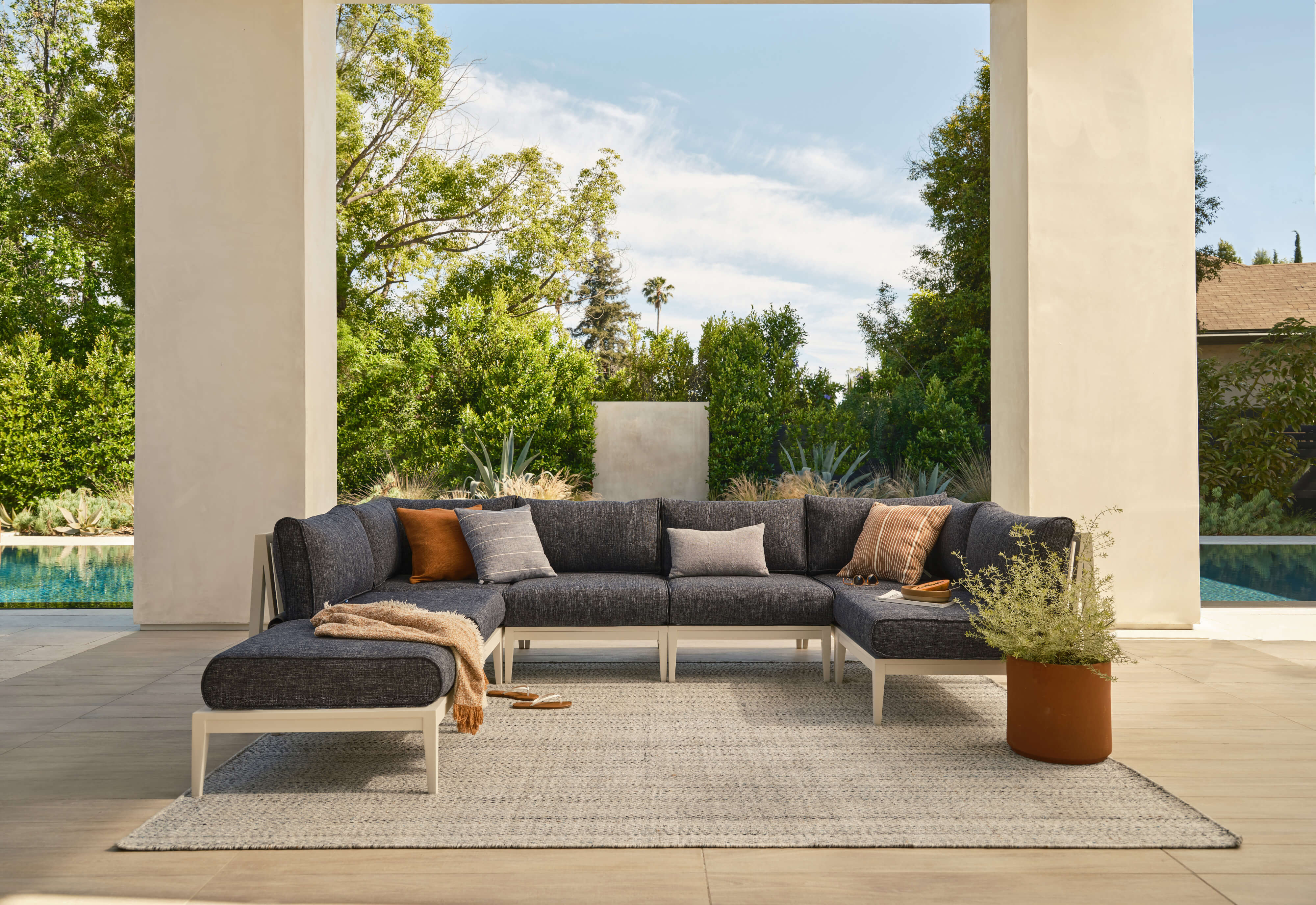 White aluminum U sectional with deep sea navy fabric and ottoman.