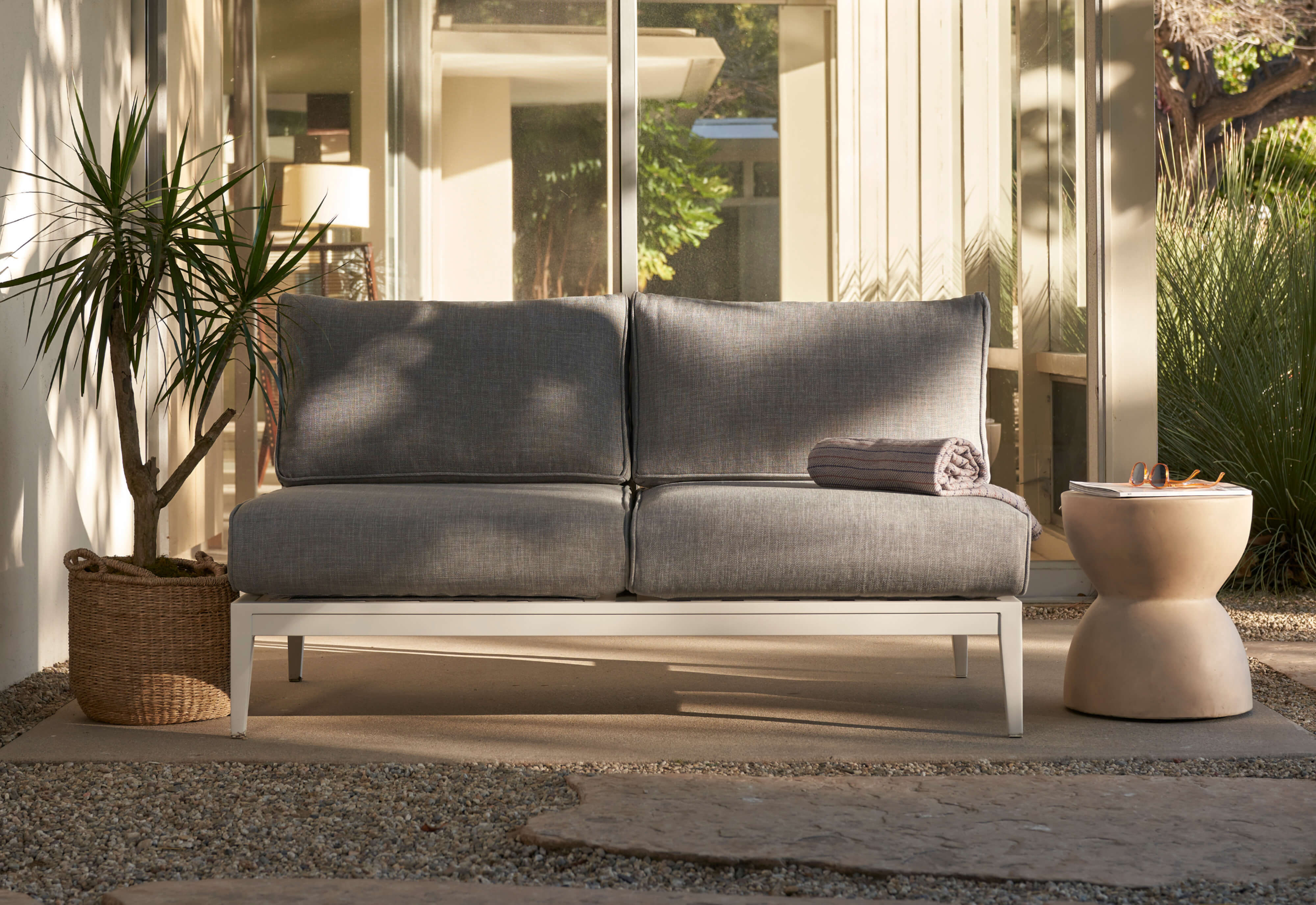 The white aluminum armless loveseat with pacific fog gray fabric.